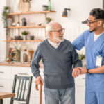 Medical worker helping his patient to move around the apartment