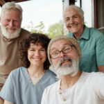 Happy young caregiver with a group of senior individuals enjoying time together on a porch. Personalized senior care in Harrisburg, PA.