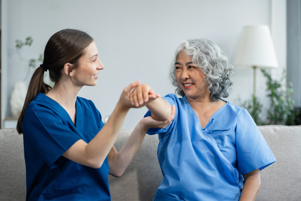 A compassionate home health caregiver assisting an elderly woman with physical therapy in Allentown, PA. Professional in-home care support by AmeriBest Home Care.